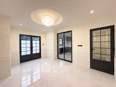 Elegant living room with chandelier and glass doors in modern home