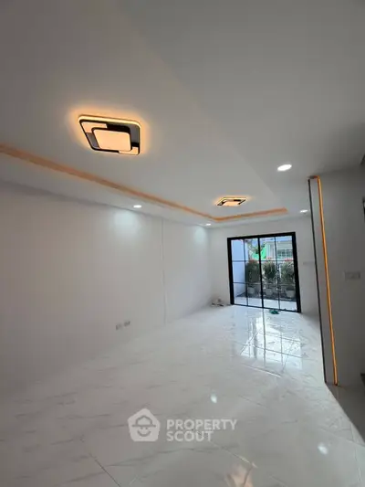 Modern interior with sleek lighting and large windows opening to a garden view.