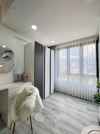 Bright and stylish bedroom with modern decor and large window view.