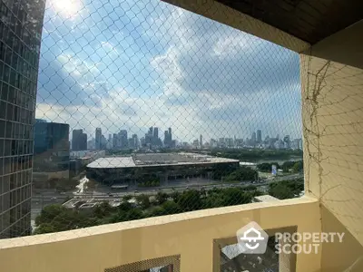 Stunning cityscape view from high-rise balcony with safety netting.