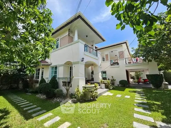 Charming two-story house with lush garden and spacious balcony, perfect for family living.