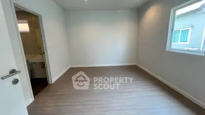 Spacious empty room with wooden flooring and natural light