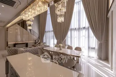 Luxurious dining area with elegant chandeliers and floor-to-ceiling windows in a modern home.