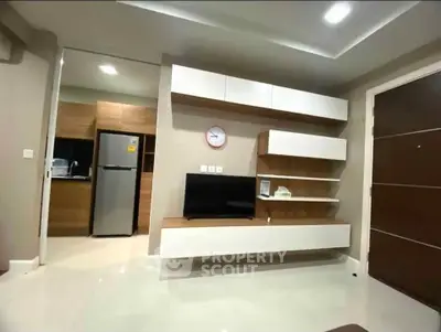 Modern living room with sleek TV unit and kitchen view