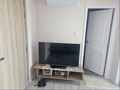 Modern living room with sleek TV setup and air conditioning unit.