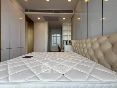 Modern bedroom with sleek design and luxurious padded headboard in a high-end apartment.