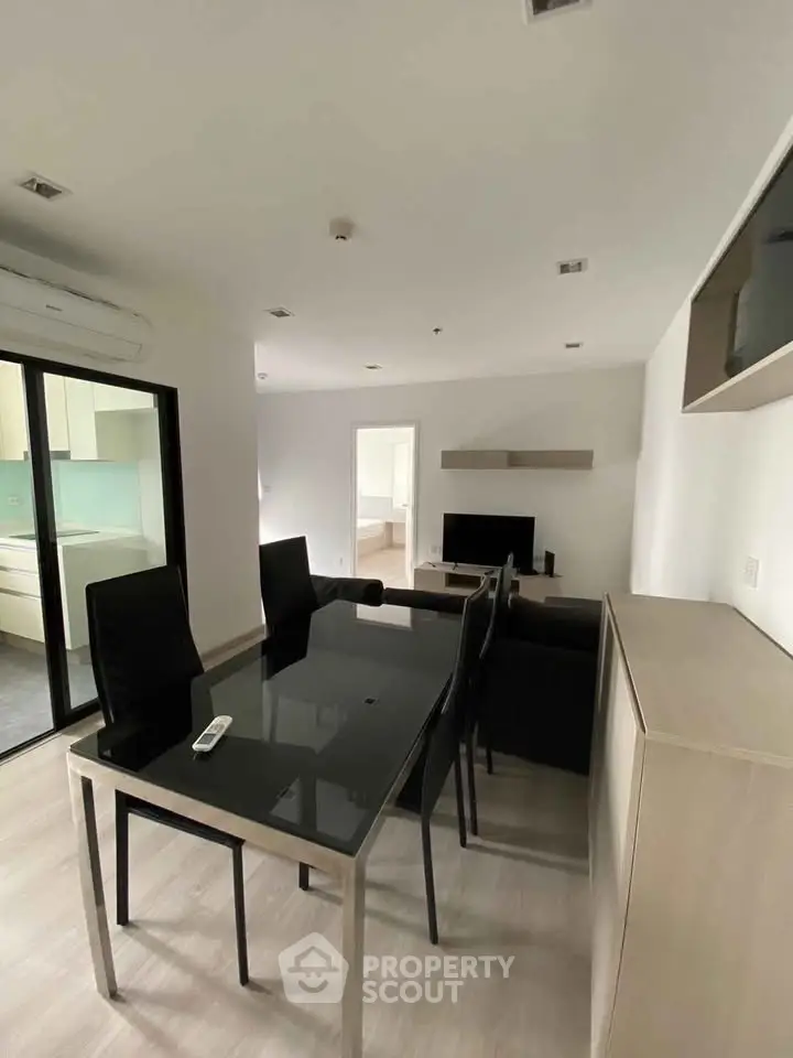 Modern living room with sleek dining area and open kitchen in a stylish apartment.