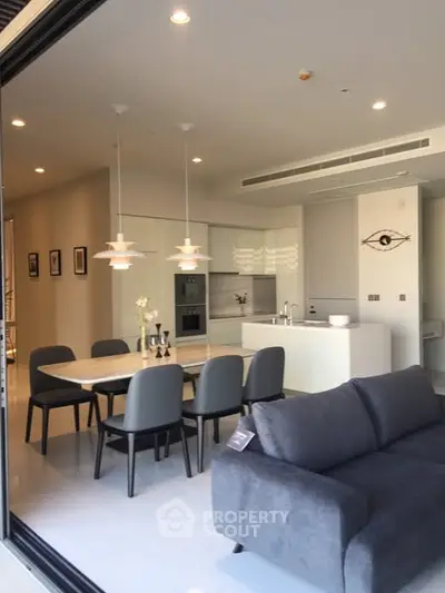 Modern open-plan kitchen and dining area with sleek design and elegant furnishings.
