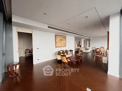 Luxurious open-plan living and dining area with elegant furnishings and hardwood floors.