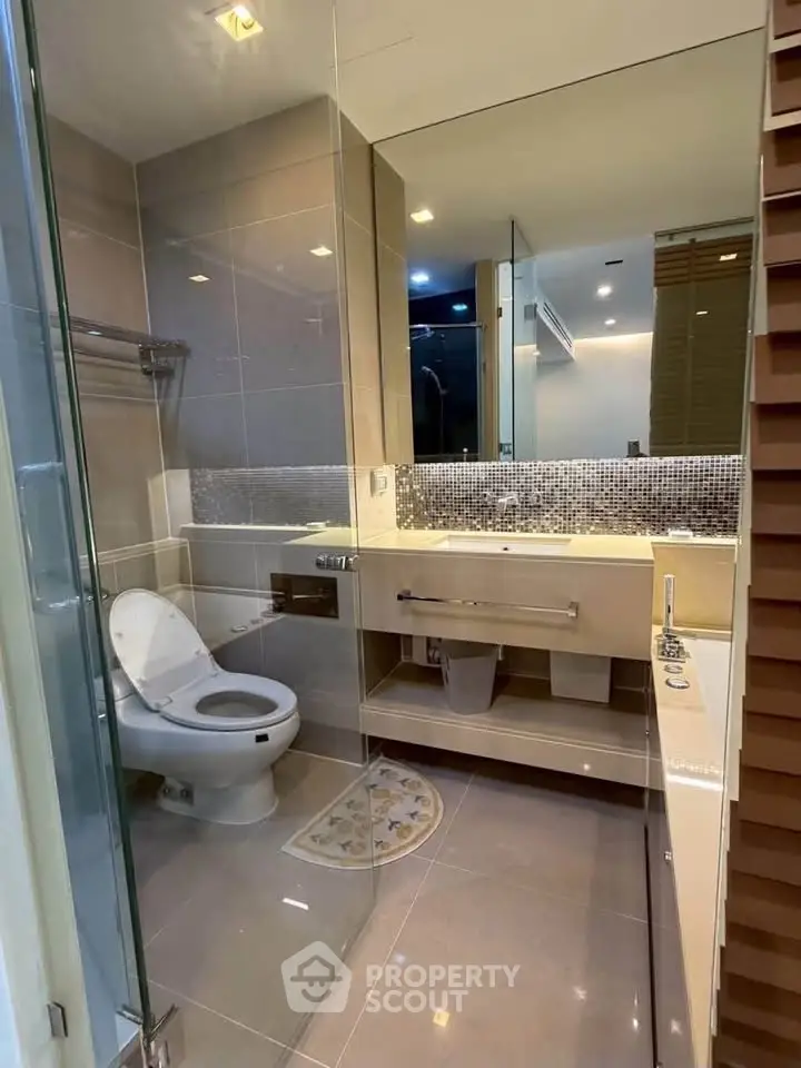 Modern bathroom with sleek fixtures and large mirror in a contemporary apartment.