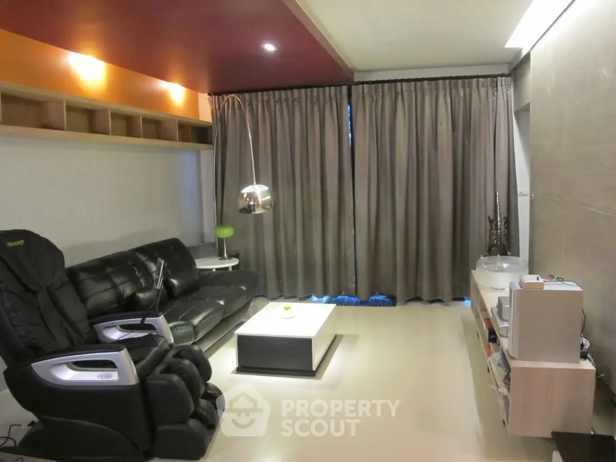 Stylish modern living room with leather seating and sleek entertainment unit.