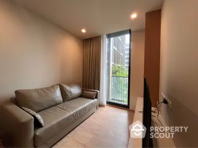 Inviting modern living room with ample natural light, featuring a plush sofa, tiled flooring, and access to a refreshing balcony with a view.