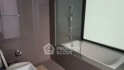 Modern bathroom with sleek design and bathtub in contemporary apartment.