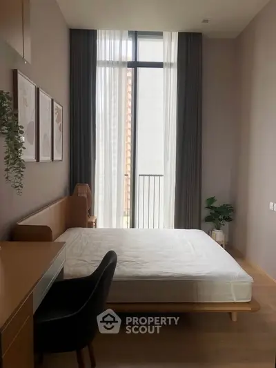Modern bedroom with large window, stylish decor, and natural light.