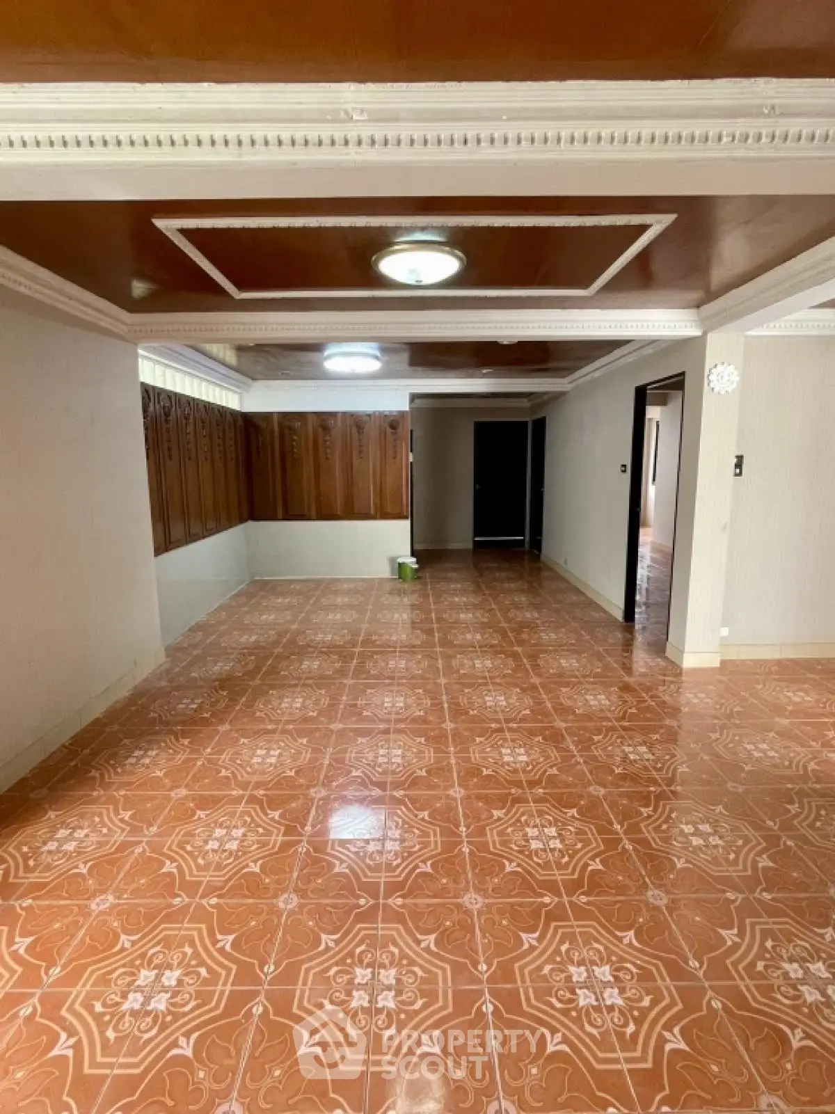 Spacious interior with decorative ceiling and tiled flooring, ideal for versatile living space.