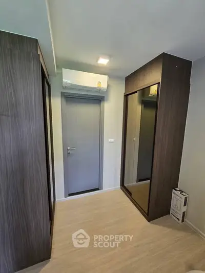 Modern storage room with sleek wooden cabinets and air conditioning unit.
