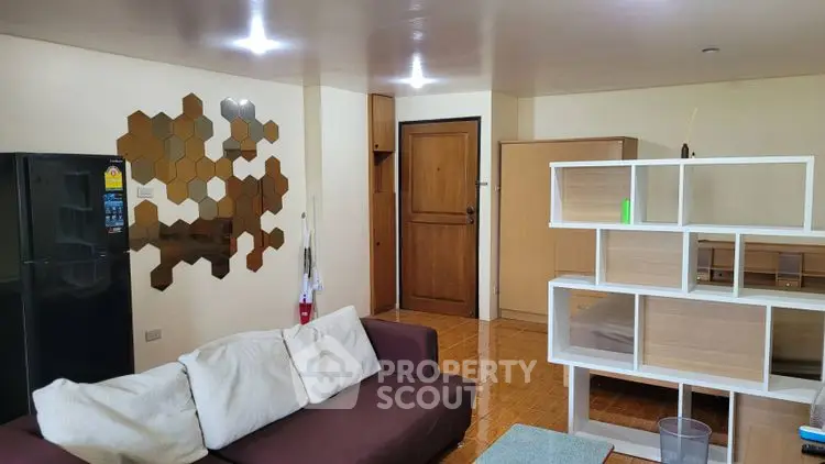 Modern living room with stylish decor and open layout, featuring a cozy sofa and unique wall art.