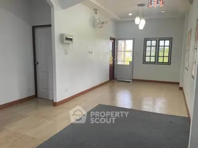 Spacious living room with modern lighting and large windows for natural light.