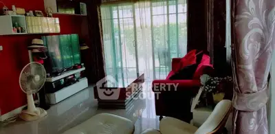 Stylish living room with modern decor and large windows opening to a lush garden view.