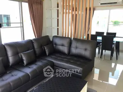 Spacious modern living room with black leather sectional sofa and dining area, perfect for entertaining.