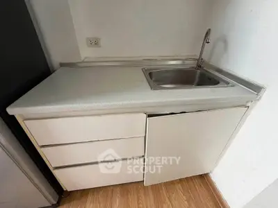 Compact kitchen corner with sink and storage in modern apartment