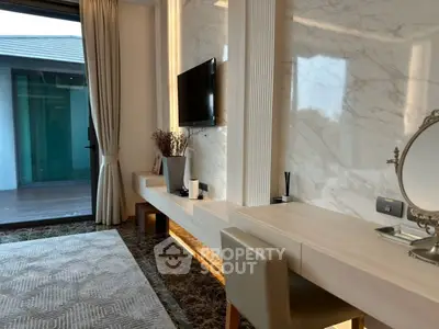 Luxurious modern living room with elegant decor and large window opening to a balcony.
