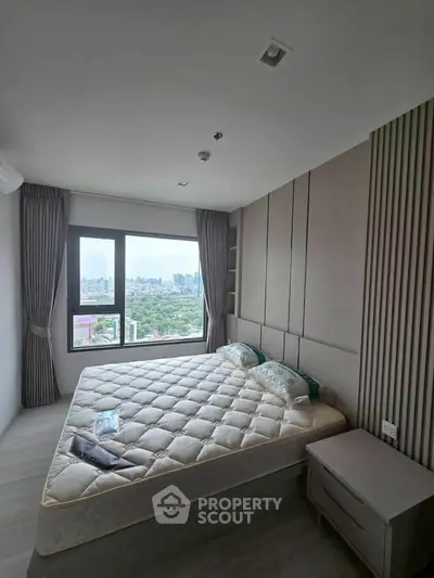 Modern bedroom with large window offering stunning city view and stylish decor.