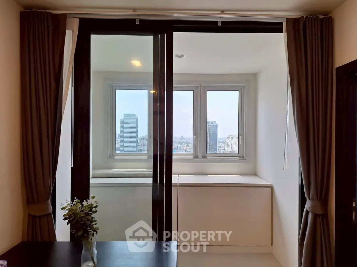 Modern apartment with large windows offering stunning city views and elegant interior design.