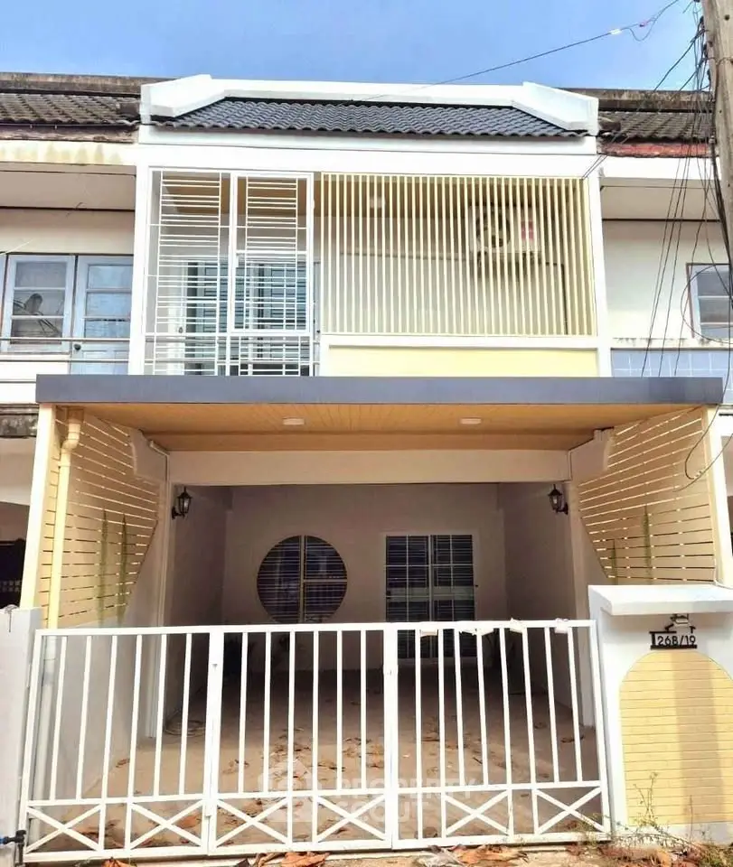 Charming two-story townhouse with gated entrance and modern facade.