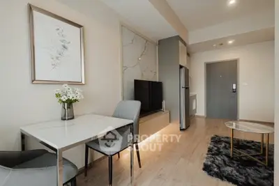 Modern living room with stylish decor and open layout, featuring a sleek TV setup and elegant dining area.
