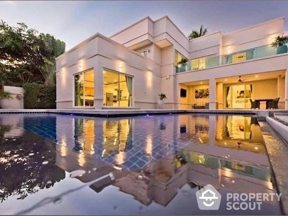 Luxurious modern villa with stunning pool and elegant architecture at sunset.