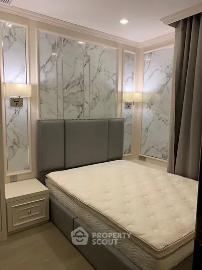 Luxurious bedroom with elegant marble wall panels and plush grey headboard for a sophisticated ambiance.