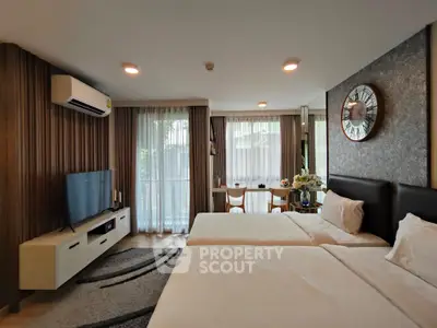 Spacious modern bedroom with twin beds, stylish decor, and natural light.