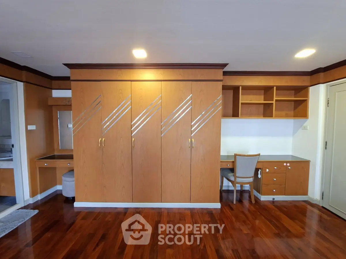 Spacious room with elegant wooden cabinetry and built-in desk, perfect for a home office or study area.