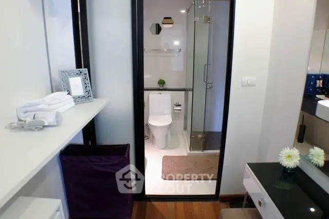 Modern bathroom with glass shower and elegant decor in a stylish apartment.