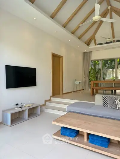 Spacious modern living room with high ceilings, wooden beams, and stylish decor in a luxury home.