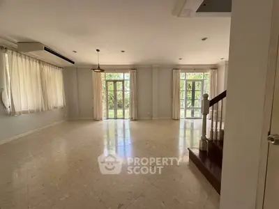 Spacious living room with large windows and natural light, perfect for family gatherings.