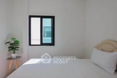 Minimalist bedroom with white bedding and natural light