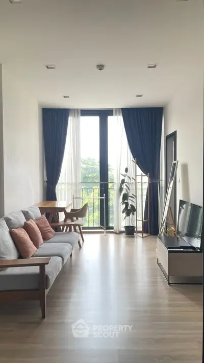 Modern living room with large windows and stylish decor, perfect for relaxation and entertaining.
