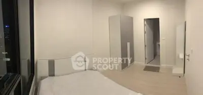 Modern minimalist bedroom with large window and sleek furniture design.