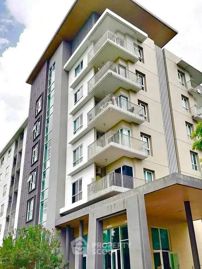 Modern multi-story apartment building with balconies and contemporary design.