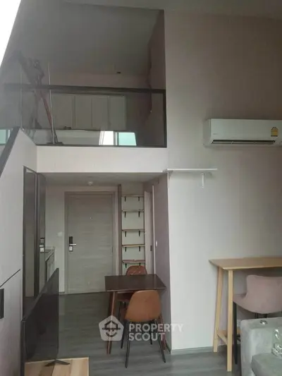 Modern loft apartment with mezzanine, stylish dining area, and sleek air conditioning unit.