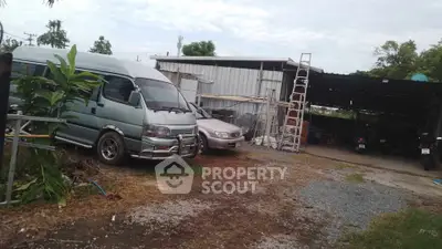 Spacious outdoor area with vehicles and storage shed, ideal for automotive enthusiasts or workshop setup.