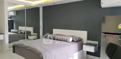 Modern bedroom with mirrored wardrobe and sleek air conditioning unit