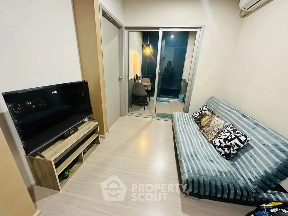 Cozy living room with modern decor and sliding glass doors leading to a balcony.