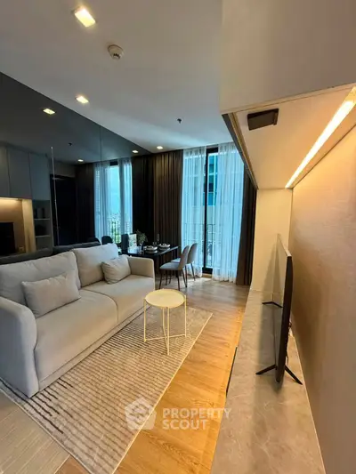 Modern living room with stylish decor and large windows offering natural light.