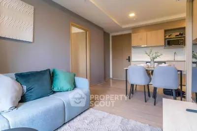 Modern living room with cozy sofa and stylish kitchen in open layout apartment.