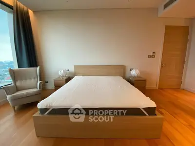 Spacious modern bedroom with wooden flooring and elegant furniture in a high-rise apartment.