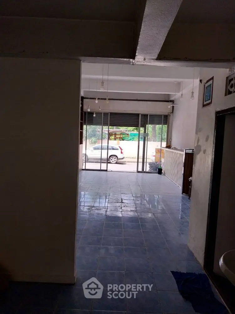 Spacious commercial space with large glass doors and tiled flooring