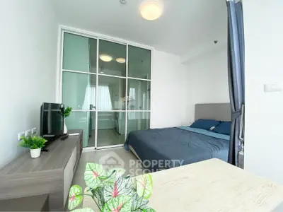 Modern bedroom with glass partition and stylish decor in a contemporary apartment.